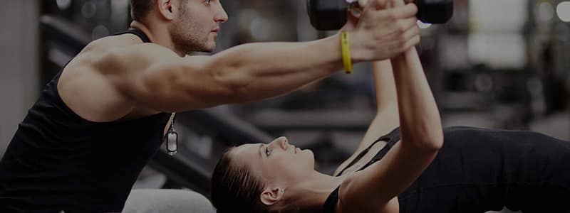 Personal trainer working with a client outdoors in a park