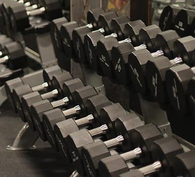 Rows of hex dumbbells on a gym rack